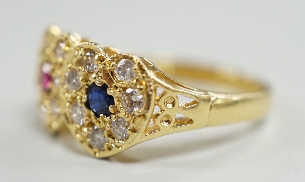 A modern 18ct gold, ruby, sapphire and diamond set twin heart cluster ring, size M, gross weight 4 grams.